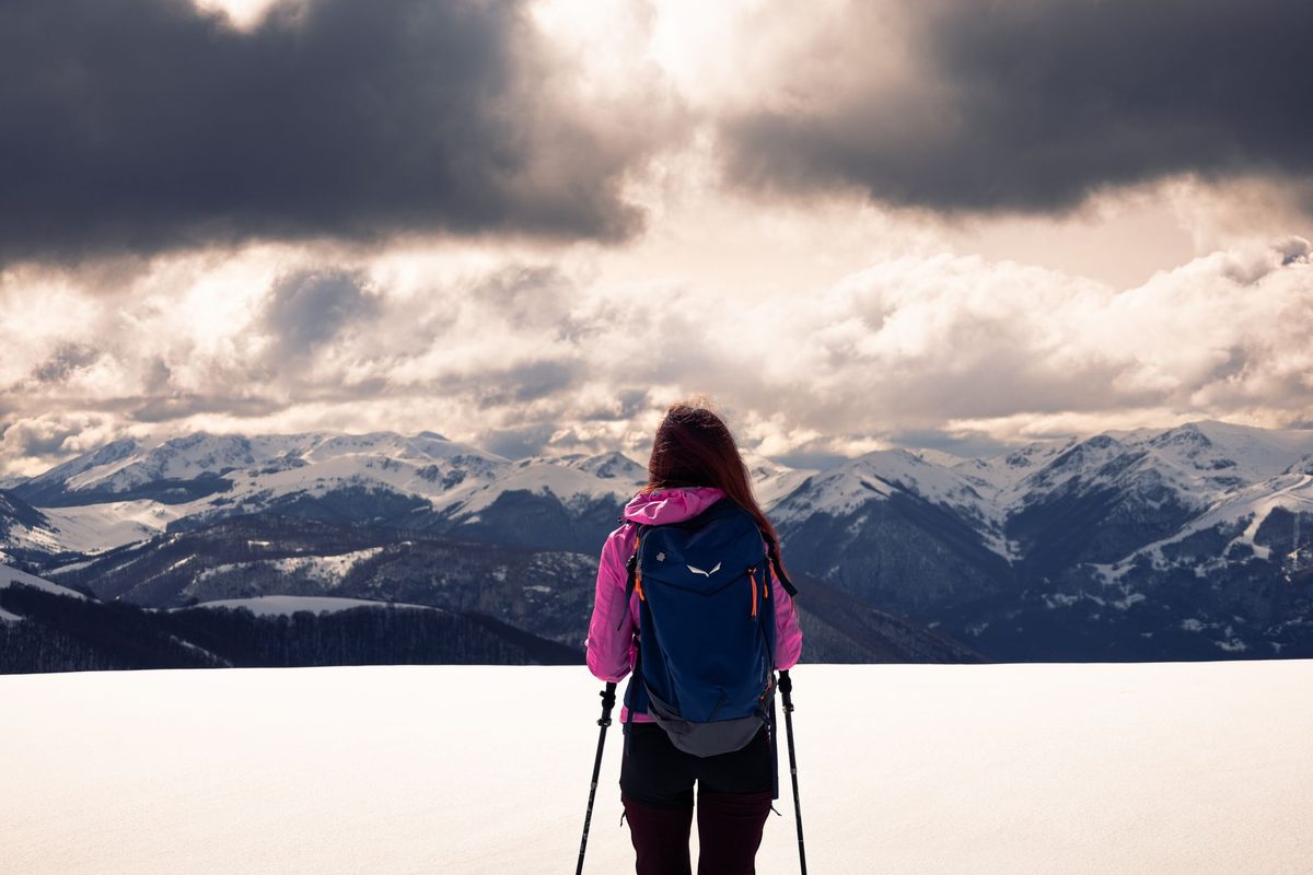 A hiker overlooking snowy mountains