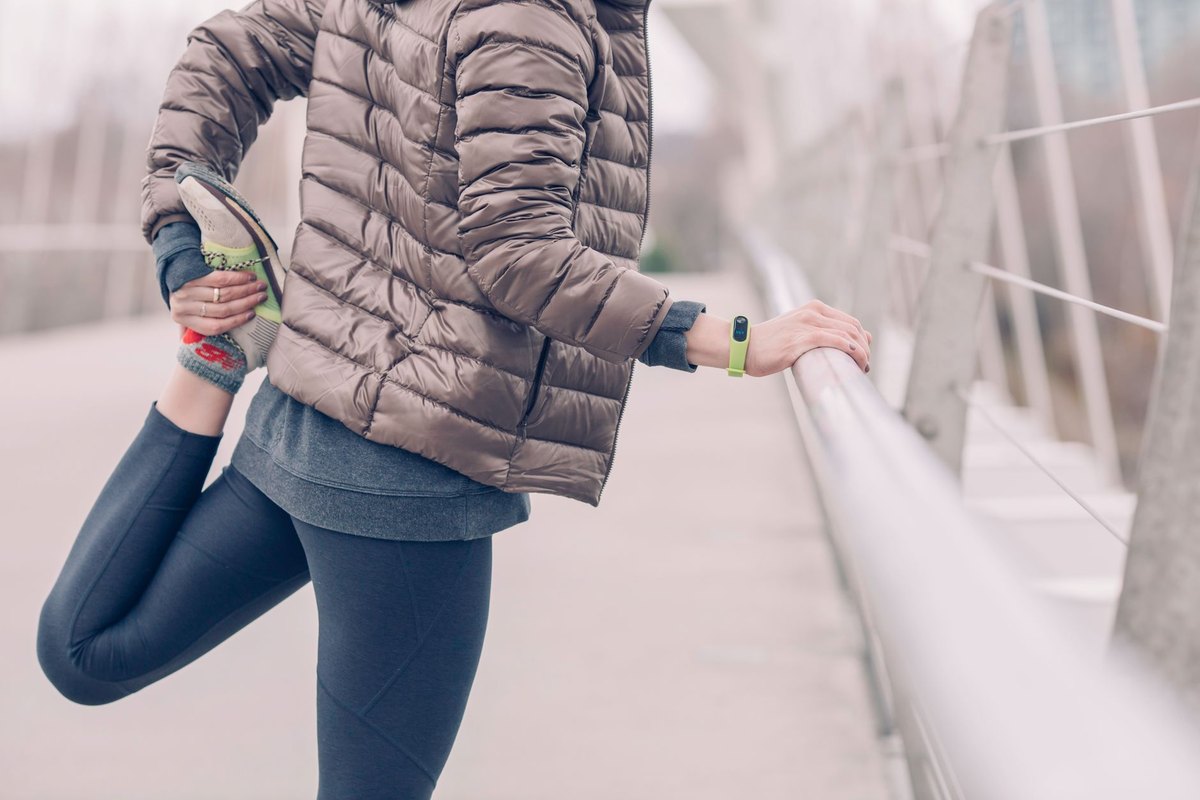 A runner stretching outdoors in winter