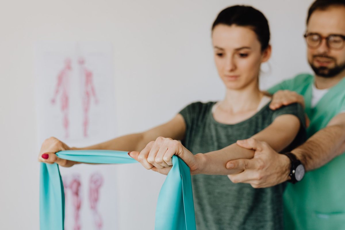 A practitioner guiding a patient through a stretch